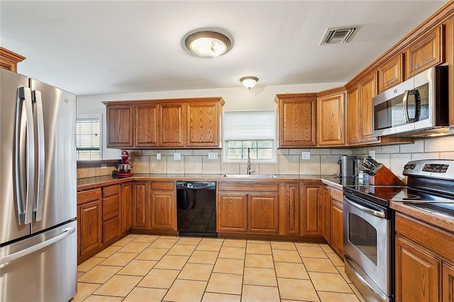 kitchen featuring tasteful backsplash, stainless steel appliances, a wealth of natural light, and sink