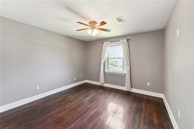 spare room featuring ceiling fan and dark wood-type flooring