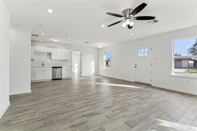 unfurnished living room with ceiling fan and sink