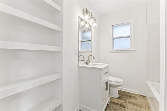 bathroom featuring hardwood / wood-style flooring, vanity, toilet, and built in features