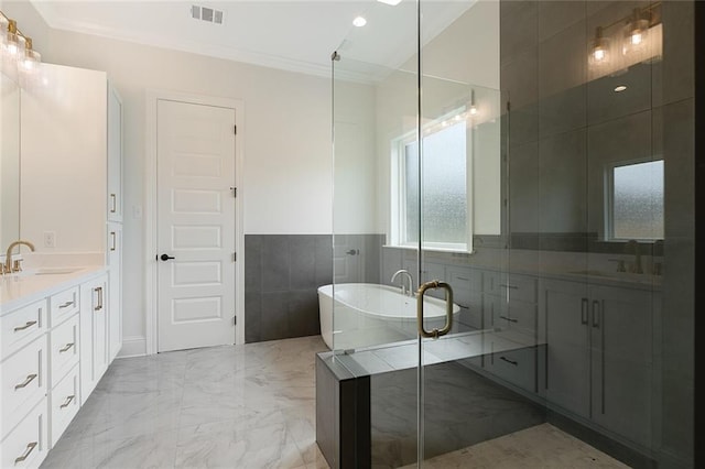 bathroom featuring plus walk in shower, vanity, tile walls, and crown molding