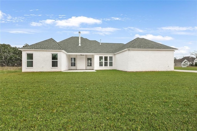 back of house with a lawn and a patio