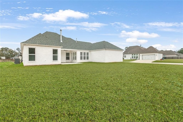 back of property with a lawn, central AC unit, and a garage