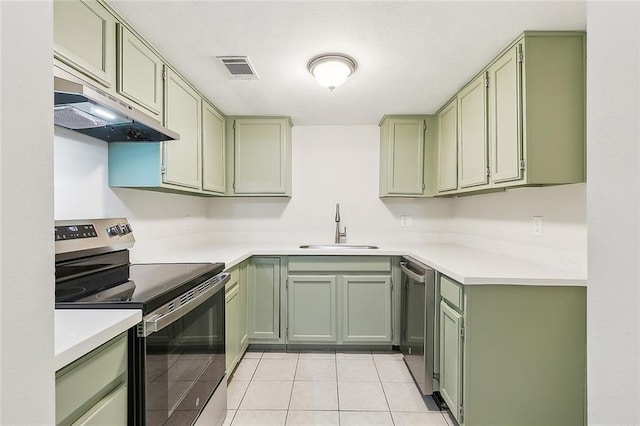 kitchen with light tile patterned floors, sink, appliances with stainless steel finishes, and green cabinetry