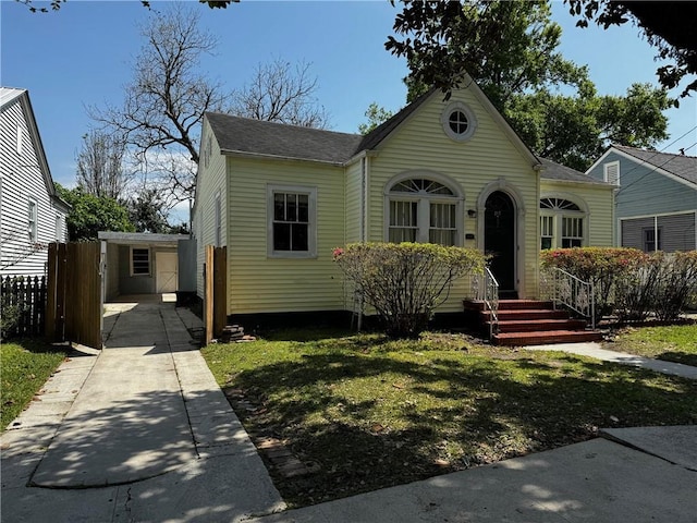 bungalow-style house with a storage shed and a front lawn