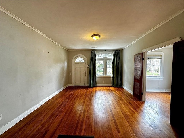 foyer entrance featuring ornamental molding, a healthy amount of sunlight, and hardwood / wood-style flooring