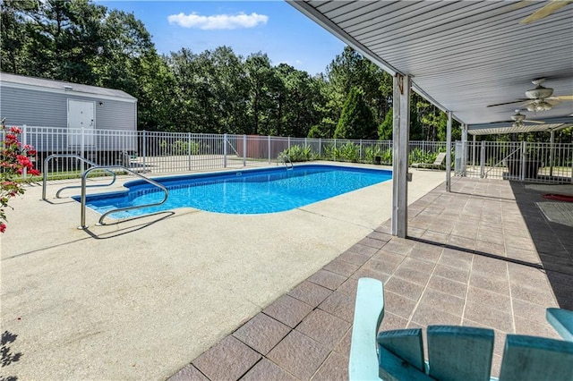 view of swimming pool featuring a fenced in pool, a patio area, fence, and ceiling fan