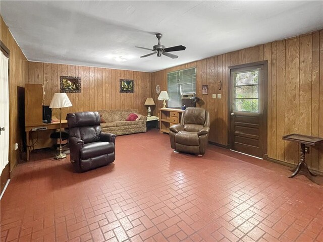 living room with ceiling fan and wooden walls