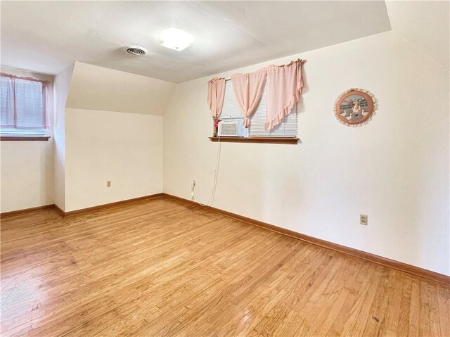 unfurnished room featuring lofted ceiling and hardwood / wood-style floors