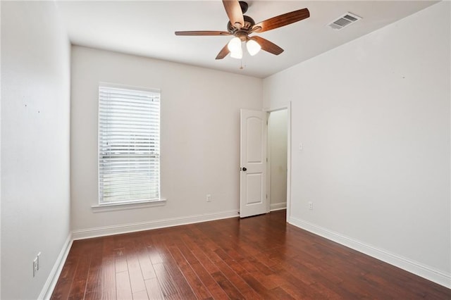 unfurnished room with a wealth of natural light, dark wood-type flooring, and ceiling fan