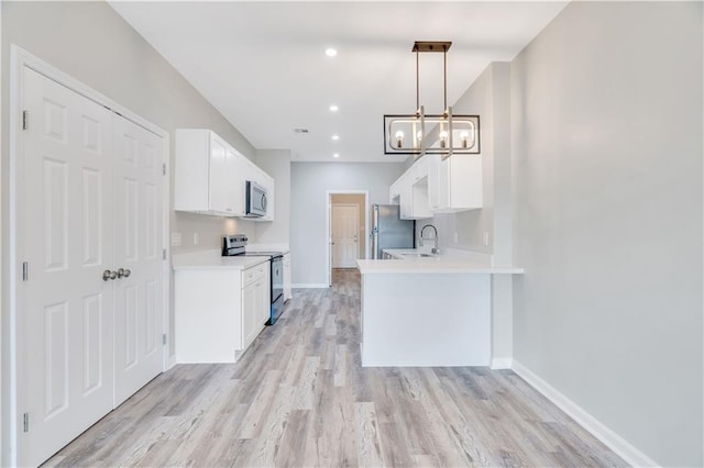 kitchen with white cabinets, sink, hanging light fixtures, appliances with stainless steel finishes, and a chandelier