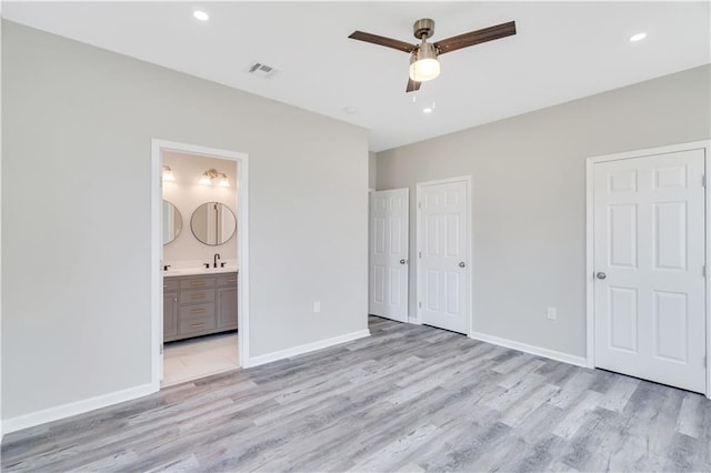 unfurnished bedroom featuring light hardwood / wood-style floors, ensuite bath, ceiling fan, and sink