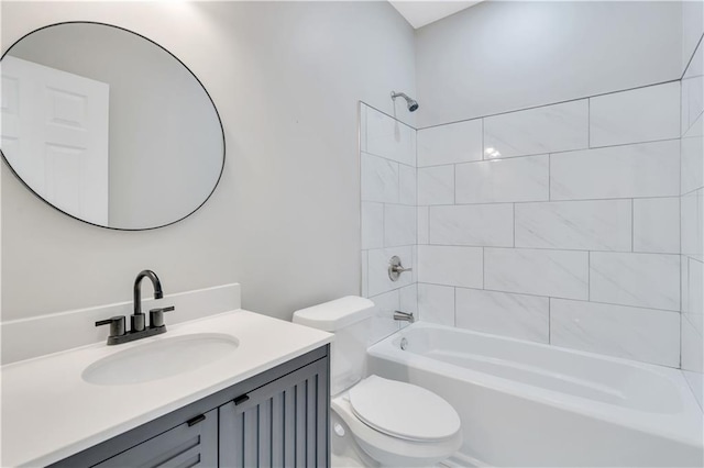 full bathroom with vanity, tiled shower / bath combo, and toilet