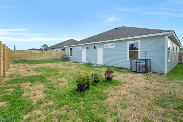 back of house with a lawn and central AC unit