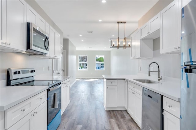 kitchen with stainless steel appliances, white cabinetry, and sink