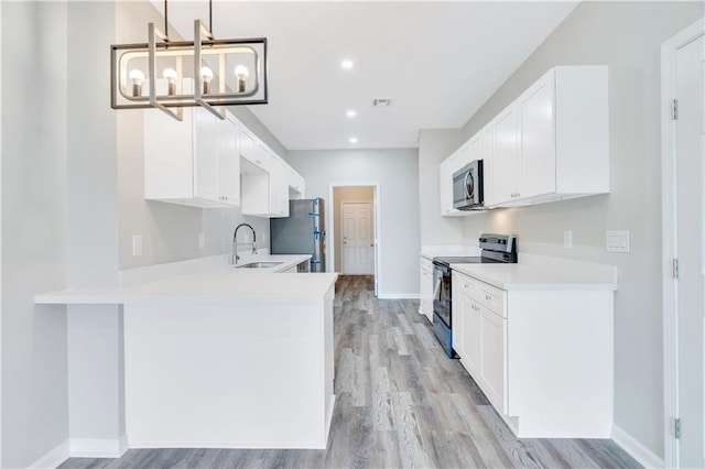 kitchen with white cabinetry, stainless steel appliances, a notable chandelier, kitchen peninsula, and decorative light fixtures