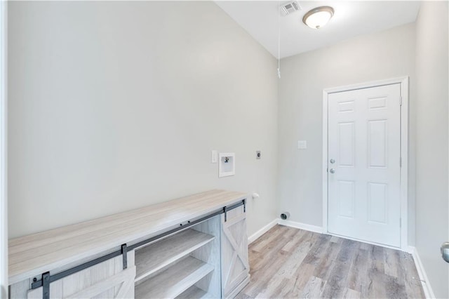 clothes washing area with washer hookup, light hardwood / wood-style floors, and electric dryer hookup