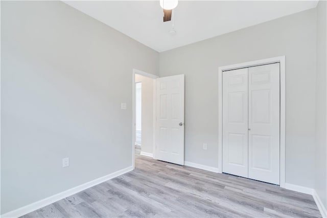 unfurnished bedroom featuring ceiling fan, a closet, and light hardwood / wood-style flooring