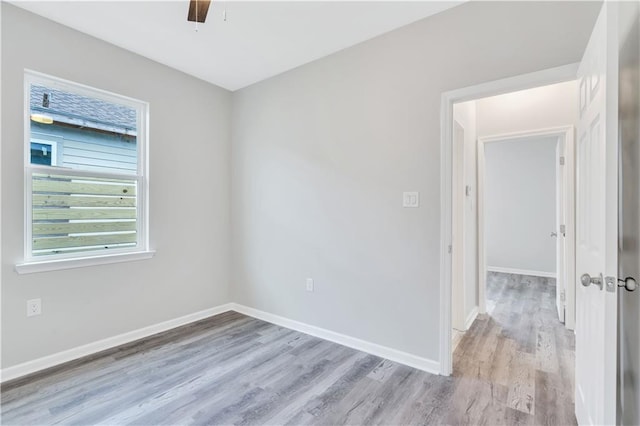 empty room with ceiling fan and light hardwood / wood-style floors