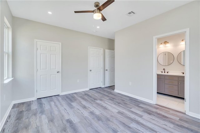 unfurnished bedroom with connected bathroom, light hardwood / wood-style floors, ceiling fan, and sink