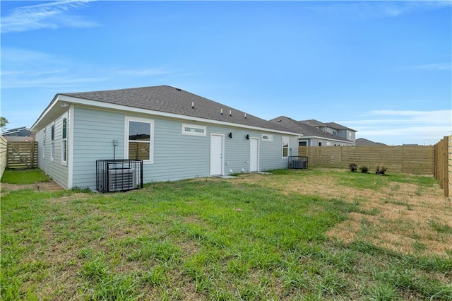 back of house with a yard and central AC