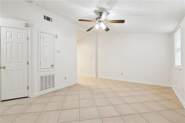 unfurnished room featuring a textured ceiling, ceiling fan, and light tile patterned flooring