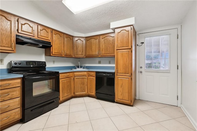 kitchen with sink, light tile patterned floors, black appliances, and a textured ceiling