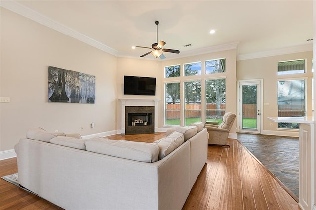 living room featuring hardwood / wood-style flooring, ceiling fan, and crown molding