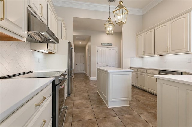 kitchen with pendant lighting, stainless steel appliances, a kitchen island, and dark tile patterned flooring