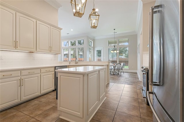 kitchen with tile patterned flooring, appliances with stainless steel finishes, a kitchen island, and pendant lighting