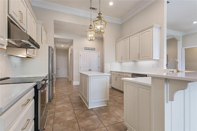 kitchen with a center island, decorative light fixtures, decorative backsplash, light tile patterned floors, and appliances with stainless steel finishes