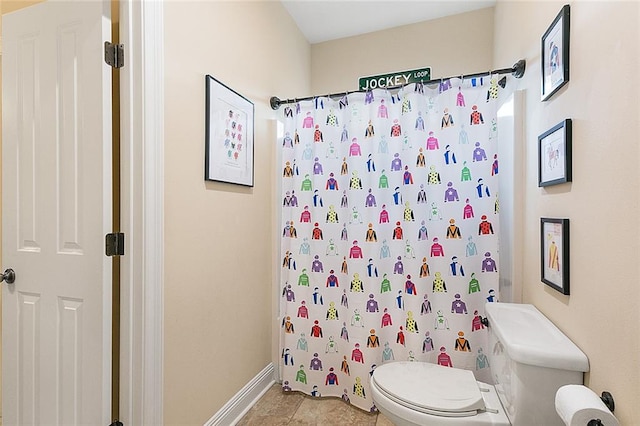 bathroom featuring a shower with shower curtain, tile patterned flooring, and toilet