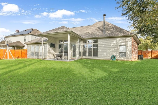 rear view of house featuring a lawn, ceiling fan, cooling unit, and a patio