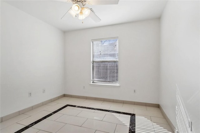 spare room with ceiling fan and light tile patterned flooring