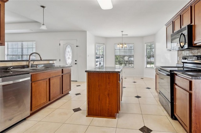 kitchen featuring a center island, black appliances, sink, hanging light fixtures, and a chandelier