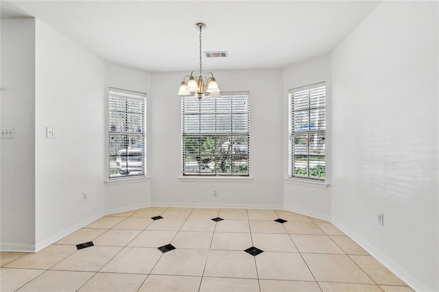 tiled empty room with a notable chandelier