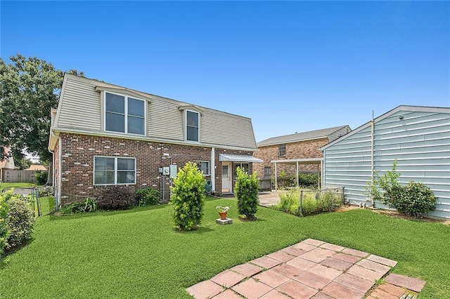 back of property with a yard and a patio