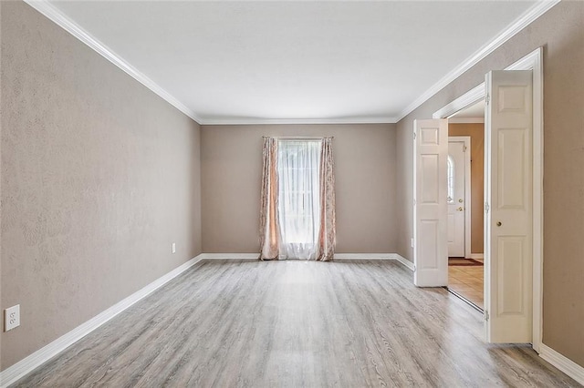 spare room with crown molding and light wood-type flooring