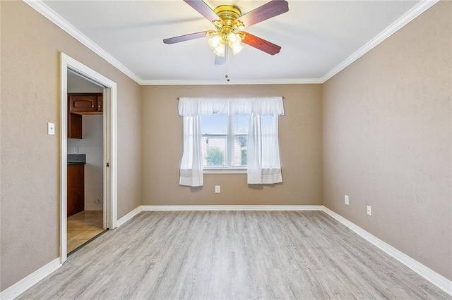 empty room featuring ceiling fan, crown molding, and light wood-type flooring