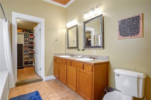 bathroom with tile patterned flooring, vanity, toilet, and crown molding