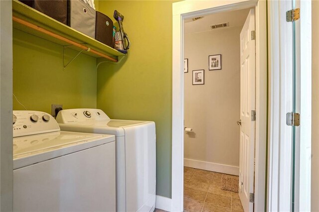 clothes washing area featuring washing machine and clothes dryer and light tile patterned floors