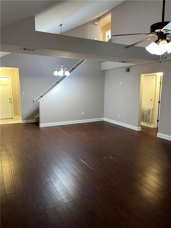 empty room featuring ceiling fan with notable chandelier, dark hardwood / wood-style flooring, and high vaulted ceiling