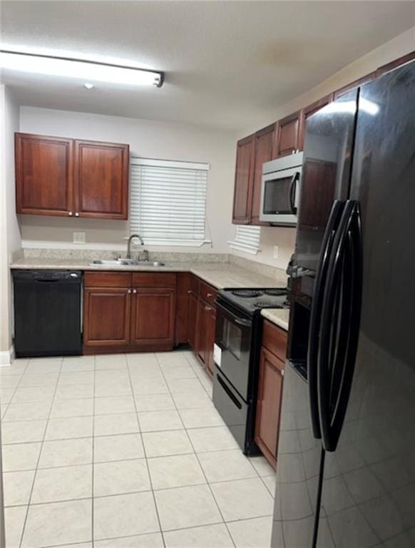 kitchen with black appliances, light tile patterned floors, and sink