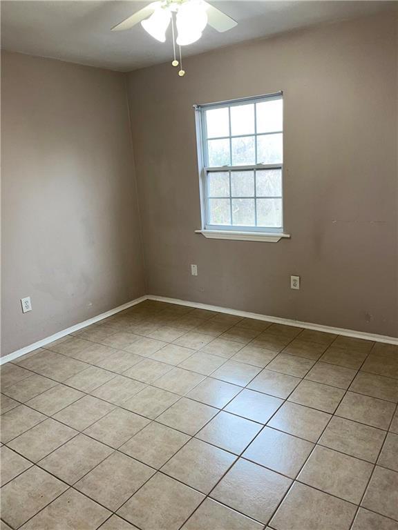 spare room featuring ceiling fan and light tile patterned flooring