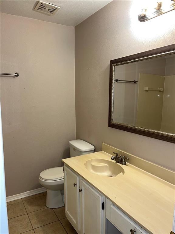 bathroom with tile patterned flooring, vanity, and toilet