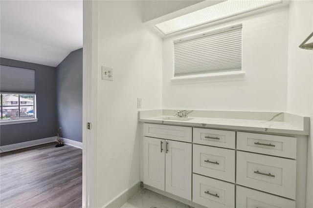 bathroom with vanity and lofted ceiling