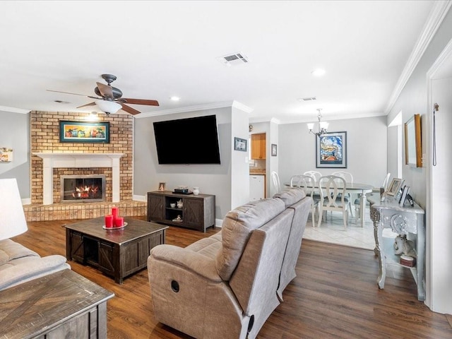 living room featuring a fireplace, wood-type flooring, ceiling fan with notable chandelier, and ornamental molding