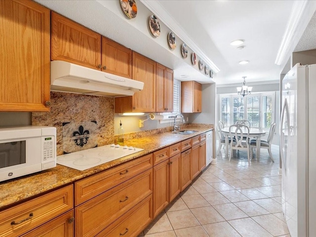 kitchen featuring tasteful backsplash, ornamental molding, white appliances, sink, and a notable chandelier