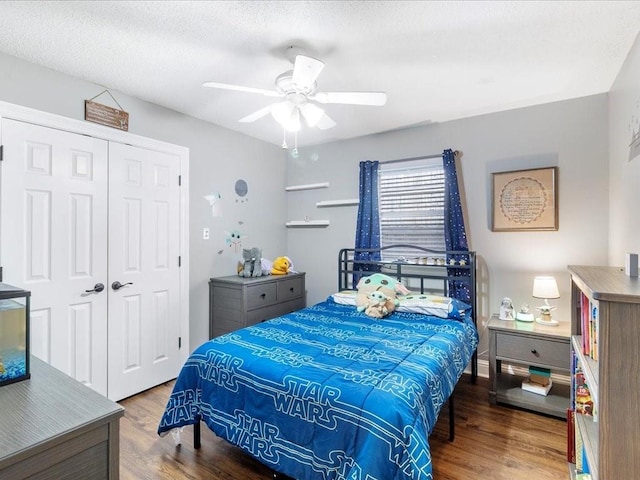 bedroom featuring ceiling fan, a closet, wood-type flooring, and a textured ceiling