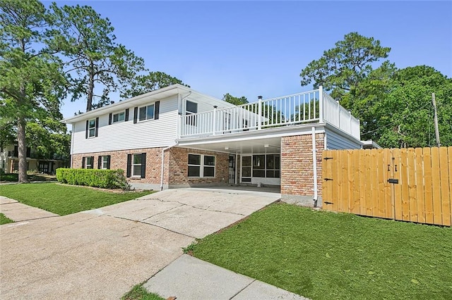 view of front facade with a balcony and a front lawn